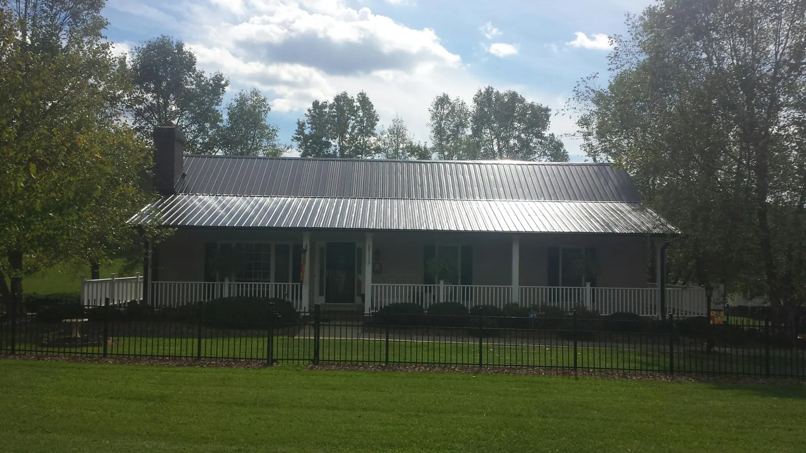 Gray metal roof on a brick ranch with a full width front porch — Gutter Guard Installation work by our crew in Poquoson