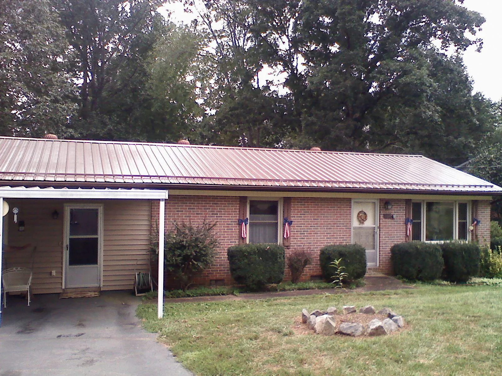 Bronze metal roof and carport on a brick ranch home — Roof Repair work by our crew in Poquoson