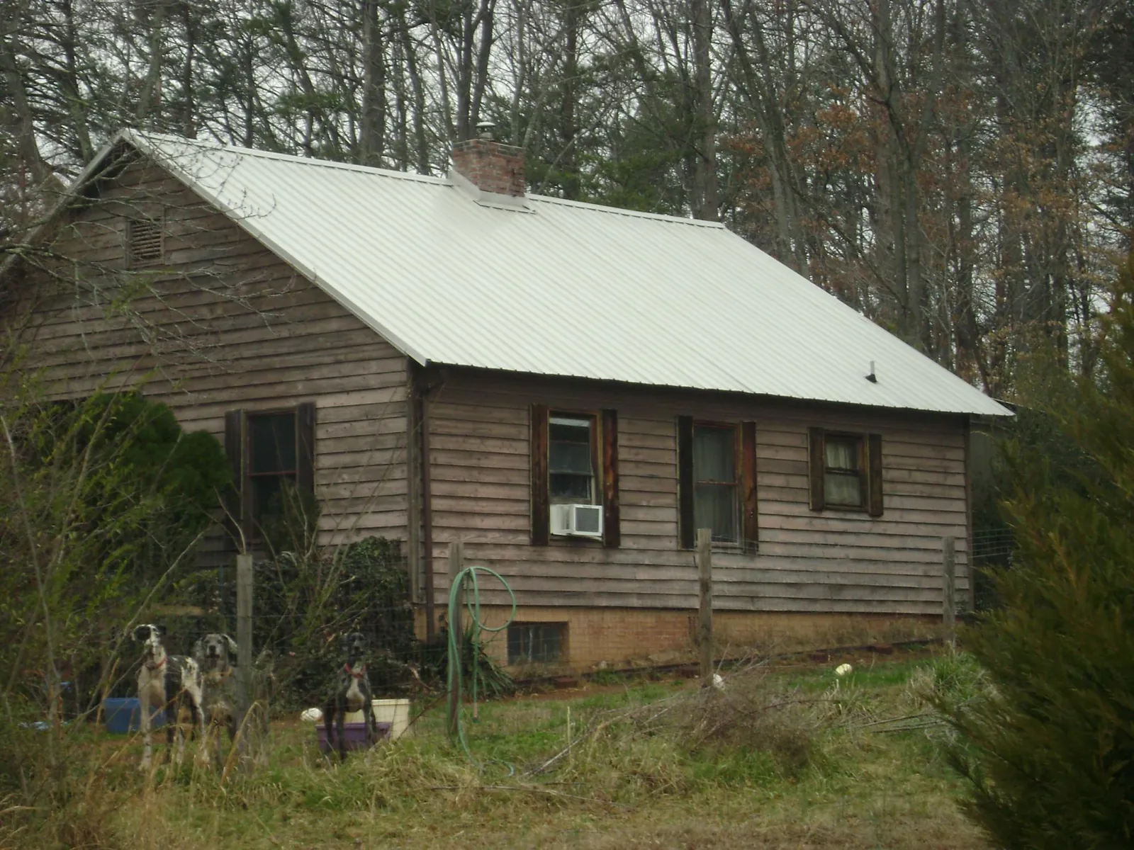White metal roof on an old wood sided farmhouse, from a Metal Roof Installation job in Poquoson